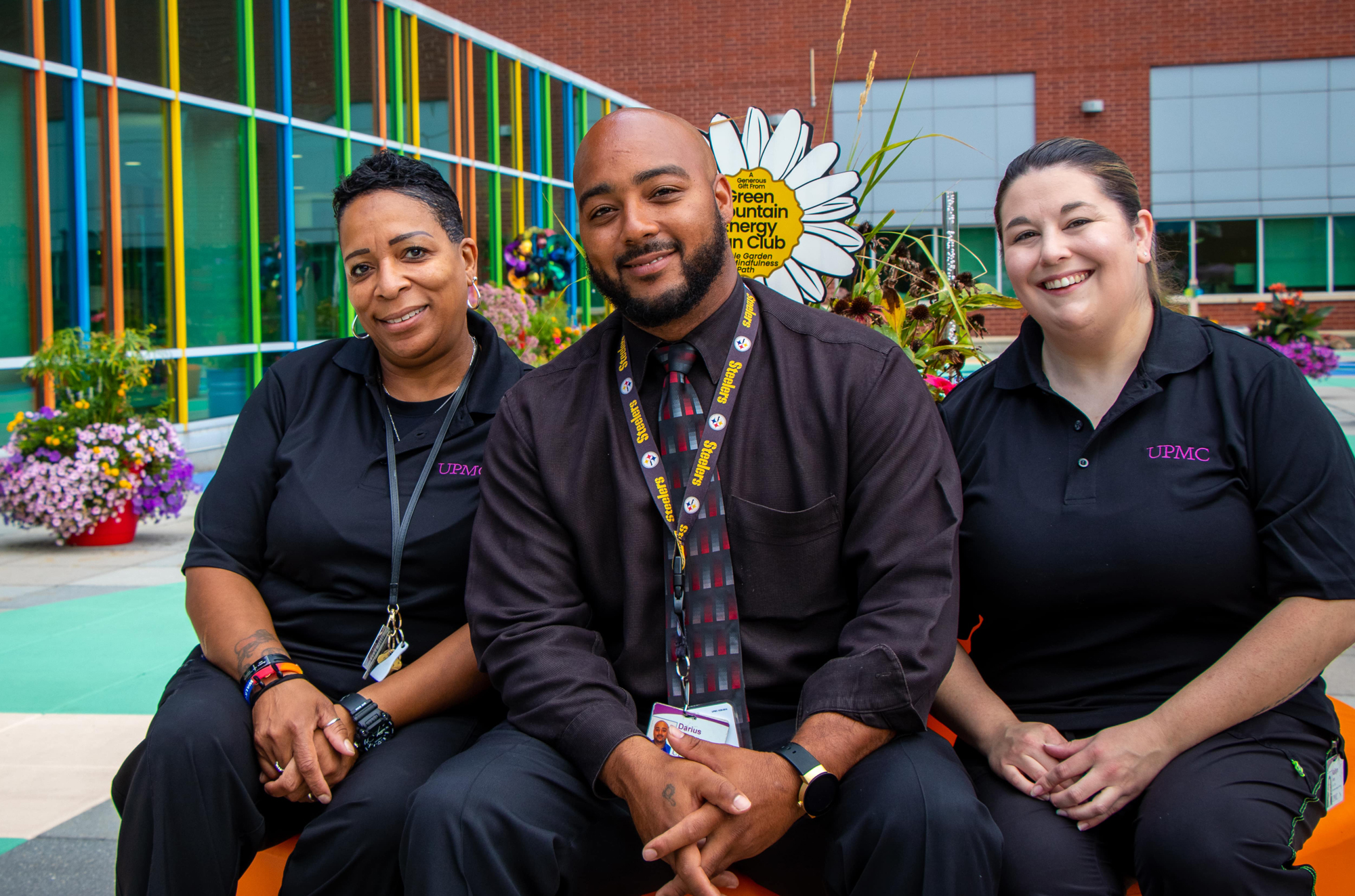 Three co-workers sit on an outdoor patio.