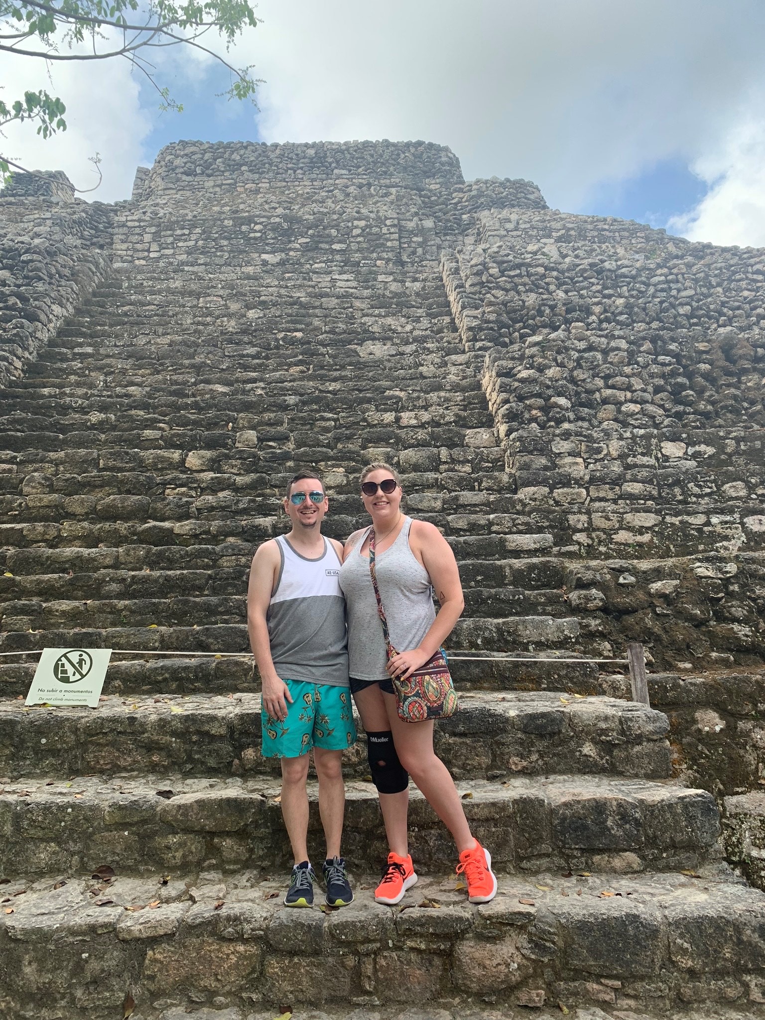 Couple stands on steps on vacation.