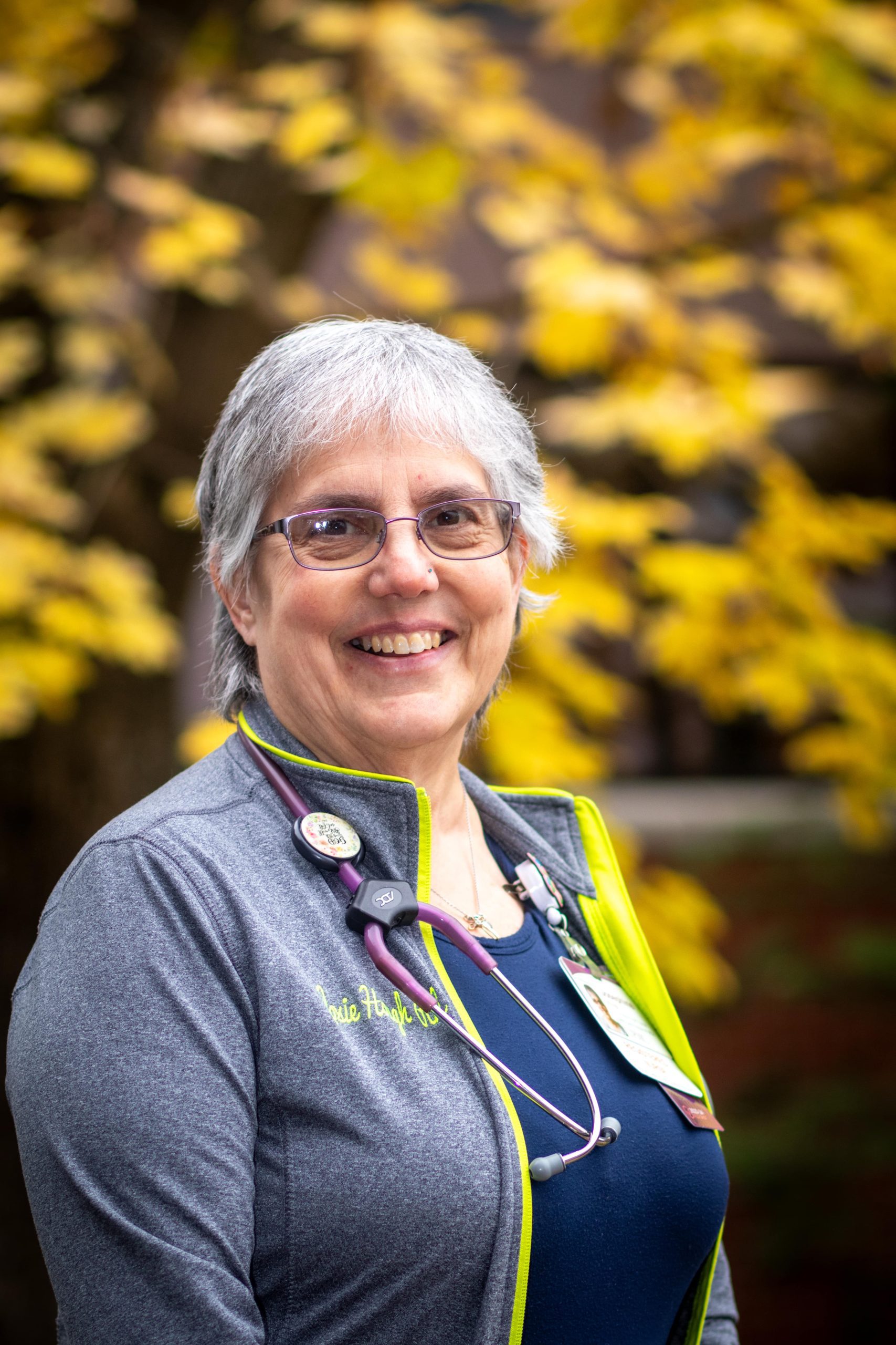 IMG_7574-min Older female nurse stands outside.