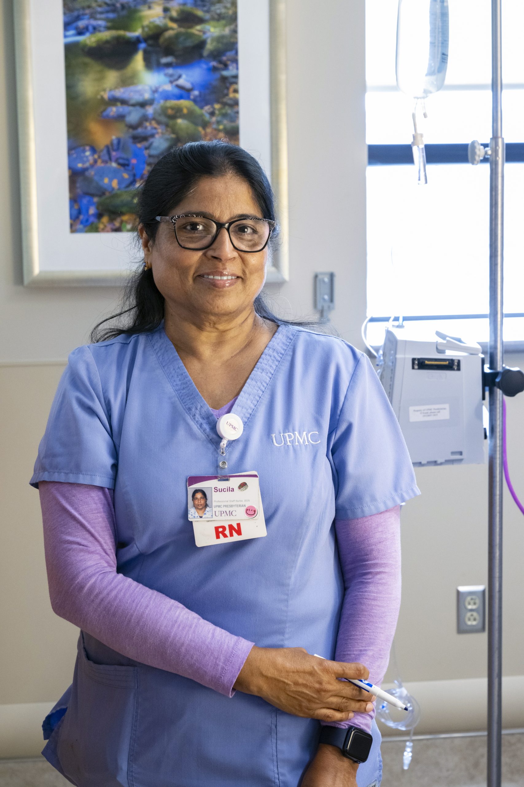 NURSING_STOCK_MUH_20230619-235_CC Middle aged nurse with glasses stands next to hospital bed.