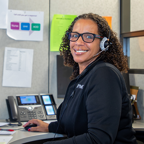 Woman with headset at her desk.